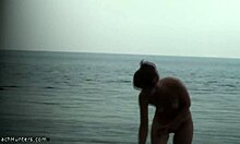 Štíhlá žena ukazuje své nahé tělo na nudistické pláži