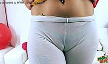 Una adolescente de trasero grande en leggings transparentes muestra su gran trasero y los dedos de camello